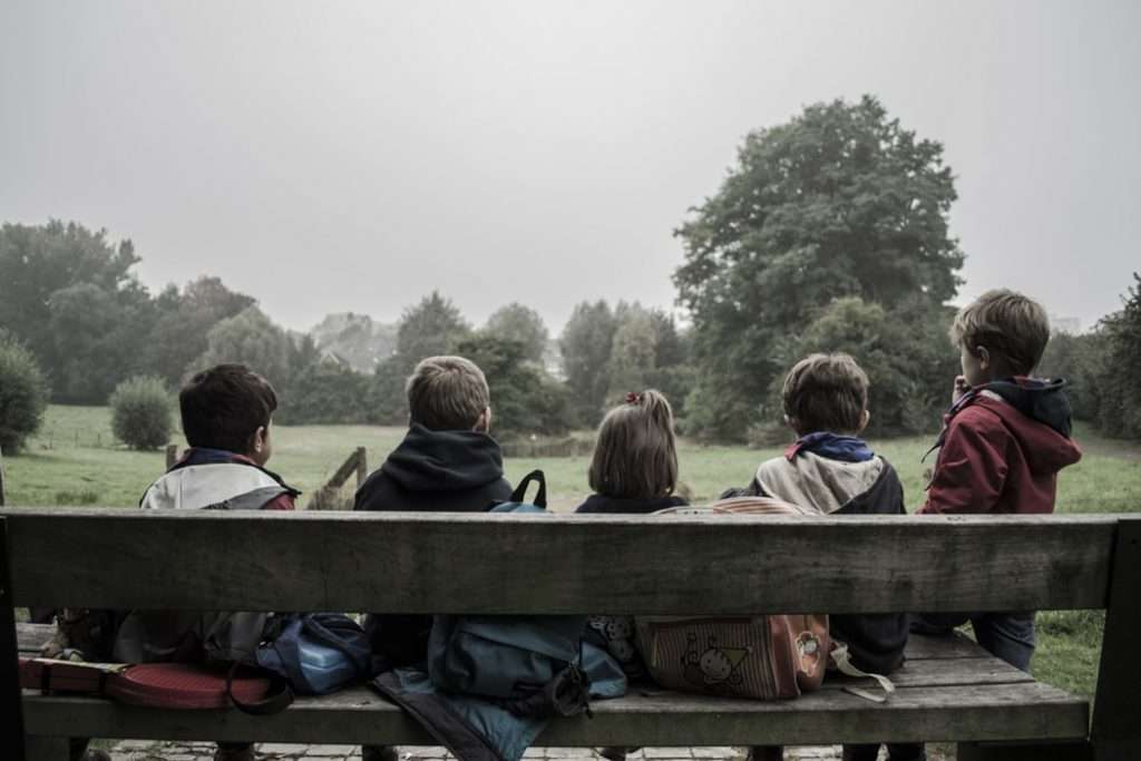 Children sat on a bench outside